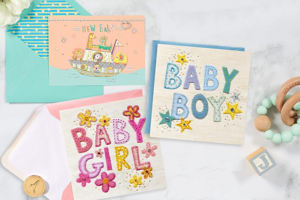 Baby Boy, Baby Girl, and New Baby Embroidered Baby Greeting Cards surrounded by Baby Toys