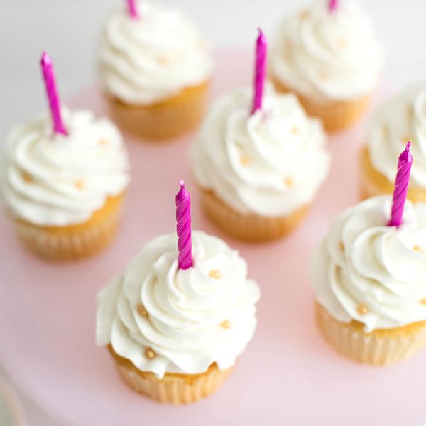 white cupcakes with pink candles
