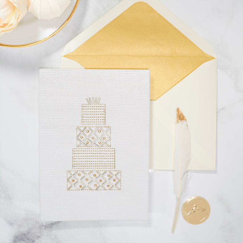 Beaded cake wedding greeting card on table with feather
