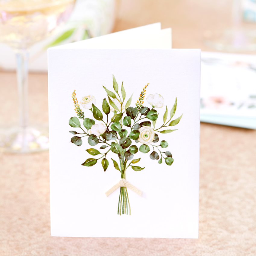 White flower with greenery bouquet wedding greeting card on table